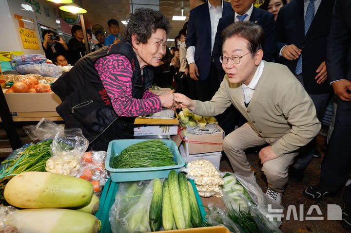 [옥천=뉴시스] 조성봉 기자 = 이재명 대통령이 대선 기간 충북 옥천군 옥천공설시장에서 상인과 대화하는 모습. (공동취재) 2025.05.06. photo@newsis.com