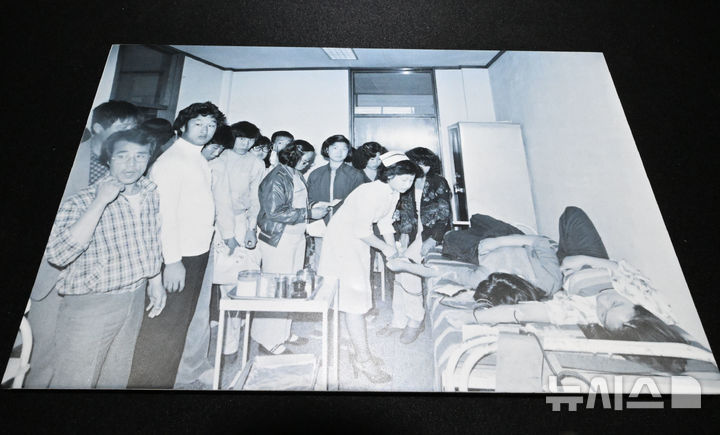 [광주=뉴시스] 이영주 기자 = 6일 오후 광주 동구 옛 적십자병원에서 이창성 전 중앙일보 기자가 5·18 당시 촬영했던 병원 내 헌혈 장면이 담긴 사진이 전시되고 있다. 옛 적십자병원은 5·18민주화운동 45주기를 맞아 5월 한달 동안 임시개방된다. 2025.05.06. leeyj2578@newsis.com
