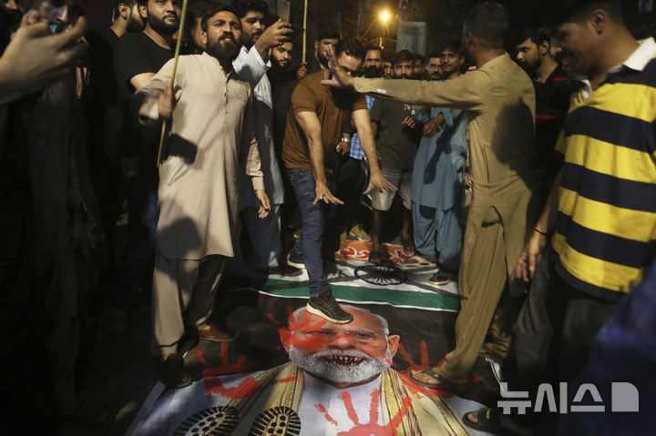 [하이데라바드=AP/뉴시스] 7일(현지 시간) 파키스탄 하이데라바드에서 인도의 미사일 공격을 규탄하는 시위가 열려 시위대가 인도 국기와 나렌드라 모디 인도 총리의 사진을 짓밟고 있다. 2025.05.07.