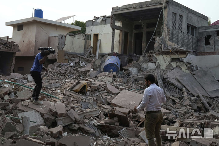 [AP/뉴시스] 7일 공습을 받은 파키스탄 동부 펀자브주 무리드케 마을에서 미디어 사진기자가 잔해 현장을 찍고 있다. 파키스탄은 인도 공습이라고 주장하고 있다.