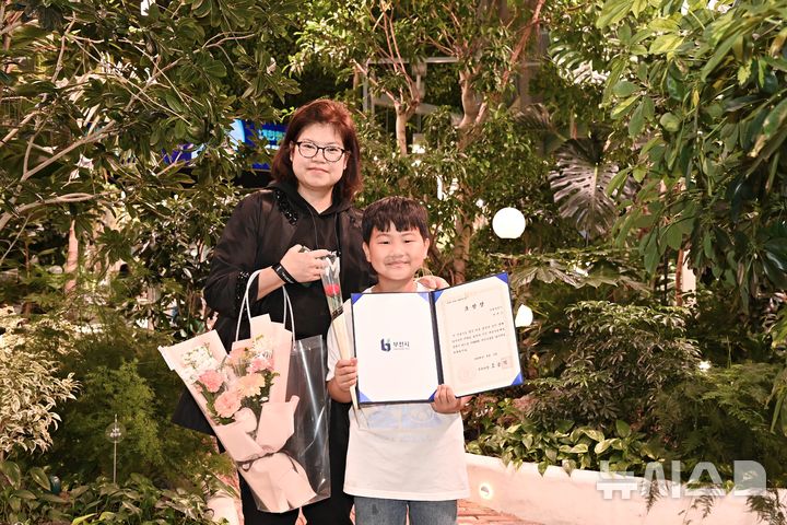 [부천=뉴시스] 정일형 기자 = 정태운 군과 그의 어머니가 부천시로부터 모범 어린이 표창장을 받은 뒤 환하게 웃고 있다. (사진=부천시 제공)