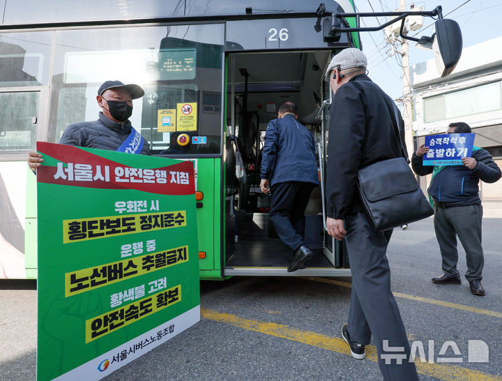 [서울=뉴시스] 김진아 기자 = 사측과의 임금·단체협약 협상이 결렬된 서울 시내버스 노조가 준법 투쟁을 재개한 7일 서울 성동구 태진운수 앞에서 노조원들이 교섭 타결을 촉구하며 안전운행이 적힌 손팻말을 들고 있다.'준법 투쟁'은 승객이 자리에 앉은 후 버스를 출발하거나 앞서가는 버스를 추월하지 않는 등의 방법으로 버스 연착을 유도하는 방식이다. 2025.05.07. bluesoda@newsis.com