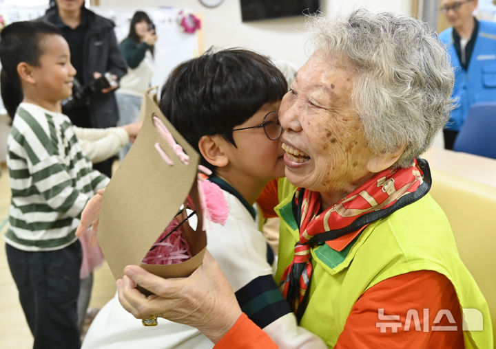 [수원=뉴시스] 김종택 기자 = 사진은 지난 5월 7일 경기 수원시 팔달노인복지관을 찾은 어린이들이 고사리 손으로 어르신들에게 카네이션을 달아드린 뒤 포옹하고 있는 모습. 2025.05.07. jtk@newsis.com