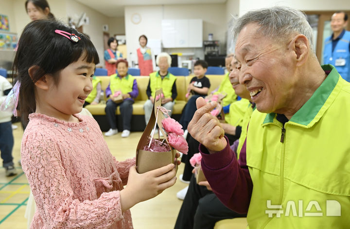 [수원=뉴시스] 김종택 기자 = 어버이날을 하루 앞둔 7일 경기 수원시 팔달노인복지관을 찾은 어린이들이 고사리 손으로 어르신들에게 카네이션을 달아주고 있다. 2025.05.07. jtk@newsis.com