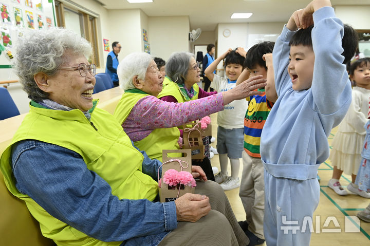 [수원=뉴시스] 김종택 기자 = 사진은 지난해 5월 7일 경기 수원시 팔달노인복지관을 찾은 어린이들이 고사리 손으로 어르신들에게 카네이션을 달아드린 뒤 하트를 그리고 있는 모습. 2025.05.07. jtk@newsis.com