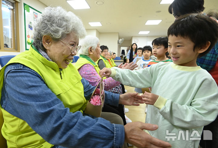 [수원=뉴시스] 김종택 기자 = 어버이날을 하루 앞둔 7일 경기 수원시 팔달노인복지관을 찾은 어린이들이 고사리 손으로 어르신들에게 카네이션을 달아주고 있다. 2025.05.07. jtk@newsis.com
