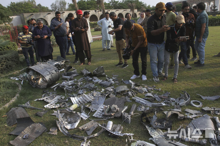 [바하왈푸르=AP/뉴시스] 인도가 미사일로 파키스탄을 공격했던 때 한국 등 여러 국가의 민간 항공기가 하늘에 있었다고 파키스탄군은 밝혔다. 사진은 파키스탄 기자들이 7일(현지 시간) 펀자브주 바하왈푸르 인근, 인도의 미사일 공격으로 파손된 사원 건물 부지에서 미사일 파편을 촬영하고 있는 모습. 2025.05.08.
