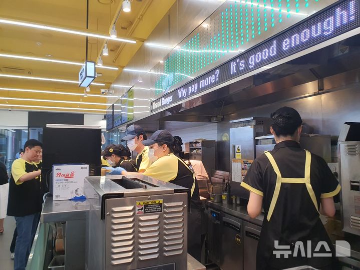 [서울=뉴시스] 서울시 코엑스 내 노브랜드 버거 매장에서 직원들이 가성비 신메뉴 라인인 'NBB어메이징 버거'를 만들고 있다. photo@newsis.com
