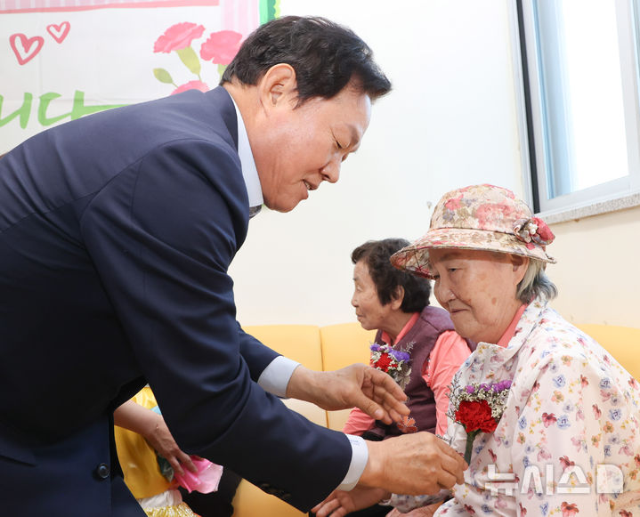 [김해=뉴시스]박완수 경남도지사가 어버이날인 8일 김해시서부노인종합복지관을 찾아 어르신 가슴에 카네이션을 달아드리고 있다.(사진=경남도 제공) 2025.05.08. photo@newsis.com