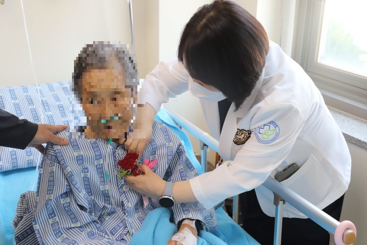 [서산=뉴시스] 충남 서산의료원 의료진이 8일 어버이날을 맞아 입원 어르신에게 카네이션을 달아드리고 있다. (사진=서산의료원 제공) 2025.05.08. photo@newsis.com&nbsp; *재판매 및 DB 금지