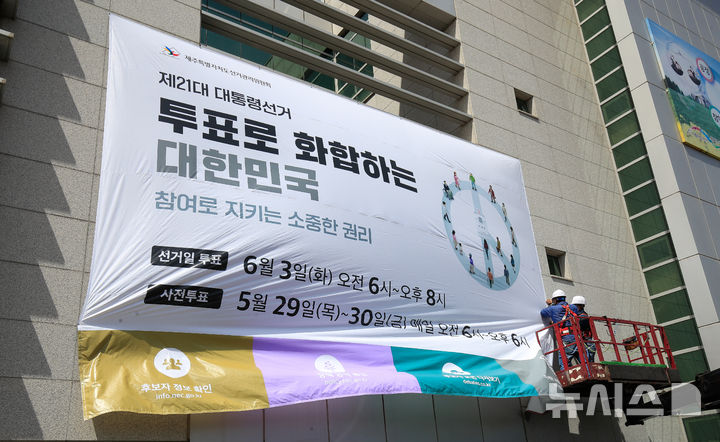 [제주=뉴시스] 우장호 기자 = 8일 오전 제주특별자치도선거관리위원회 동측 벽면에 제21대 대통령 선거 투표참여를 독려하는 대형 현수막 게시 작업이 이뤄지고 있다. 2025.05.08. woo1223@newsis.com