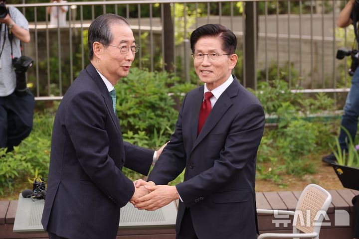 [서울=뉴시스] 권창회 기자 = 김문수 국민의힘 대선 후보와 한덕수 무소속 대선 후보가 8일 서울 여의도 국회 강변서재 야외에서 단일화 관련 회동을 하며 악수를 하고 있다.(공동취재) 2025.05.08. photo@newsis.com