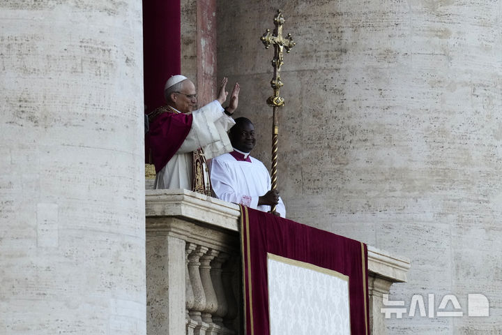 [바티칸=AP/뉴시스] 8일(현지 시간) 제267대 교황으로 선출된 미국의 로버트 프랜시스 프레보스트(69) 추기경이 선출 직후 바티칸 성베드로 대성당 중앙 '강복의 발코니'에서 인사하고 있다. 새 교황의 즉위명은 '레오 14세'로  '레오'는 라틴어로 '사자'를 뜻한다. 2025.05.09.