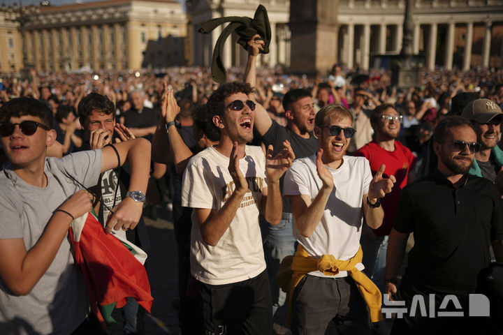 <font style="vertical-align: inherit;"><font style="vertical-align: inherit;">[바티칸=AP/뉴시스] 8일(현지 시간) 바티칸 성 베드로 대성당 앞에 모인 시민들이 새 교황이 선출되자 환호하고 있다. 이날 미국의 로버트 프랜시스 프레보스트 추기경이 제267대 교황으로 선출됐다. 새 교황의 즉위명은 '레오 14세'로 '레오'는 라틴어로 '사자'를 뜻한다. 2025.05.09.</font></font>