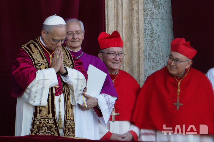 [바티칸=AP/뉴시스] 8일(현지 시간) 제267대 교황으로 선출된 미국의 로버트 프랜시스 프레보스트(69, 왼쪽) 추기경이 선출 직후 바티칸 성베드로 대성당 중앙 '강복의 발코니'에서 인사하고 있다. 새 교황의 즉위명은 '레오 14세'로 '레오'는 라틴어로 '사자'를 뜻한다. 2025.05.09.