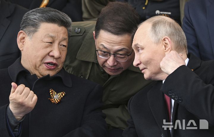 [모스크바=AP/뉴시스] 블라디미르 푸틴 러시아 대통령(오른쪽)과 시진핑 중국 국가주석이 지난달 9일(현지 시간) 러시아 모스크바 붉은광장에서 열린 제2차 세계대전 승리 80주년(전승절) 기념 열병식을 지켜보면서 얘기를 나누고 있다. 2025.06.18