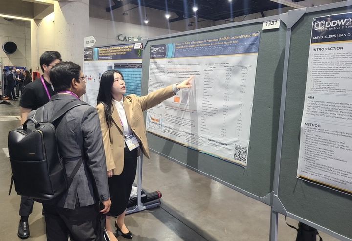 [서울=뉴시스] 해외 의료진(왼쪽)이 펙수클루(펙수프라잔)의 NSAIDs 유도 소화성궤양 예방 임상연구 결과를 보고 있다. (사진=대웅제약 제공) 2025.05.09. photo@newsis.com *재판매 및 DB 금지