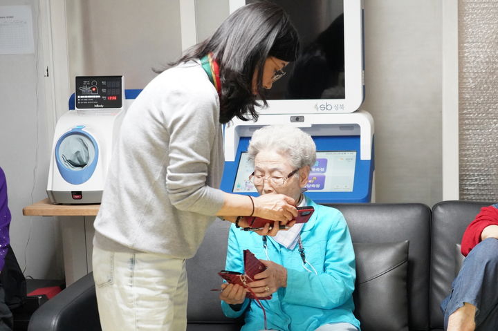 [서울=뉴시스] 성북구 스마트매니저가 관내 경로당 어르신들에게 해킹 피해를 예방할 수 있는 방법을 안내하고 있다. 2025.05.09 (사진 제공=성북구청) photo@newsis.co m *재판매 및 DB 금지