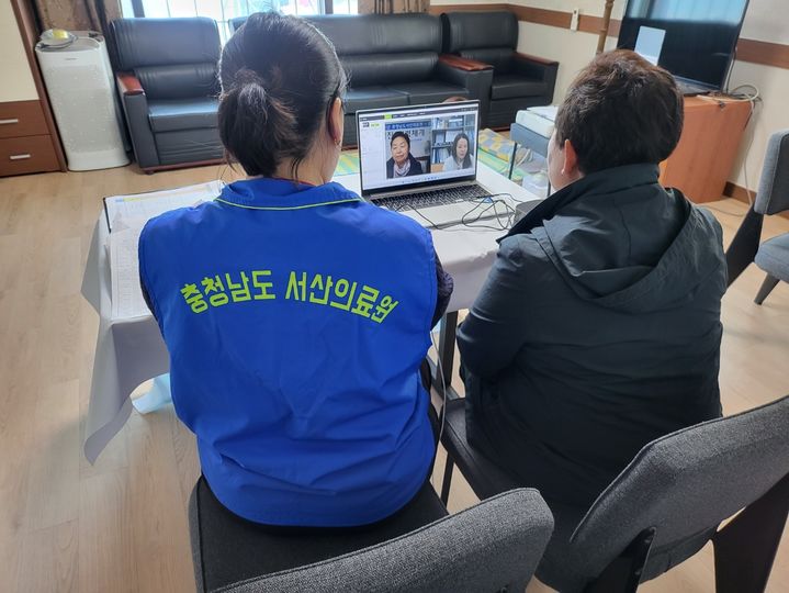 [서산=뉴시스] 지난 7일 충남 당진시 난지도 주민이 마을회관에서 서산의료원 간호사와 함께 의료원 본원 전문의를 통한 원격 진료를 받고 있다. (사진=서산의료원 제공) 2025.05.09. photo@newsis.com *재판매 및 DB 금지