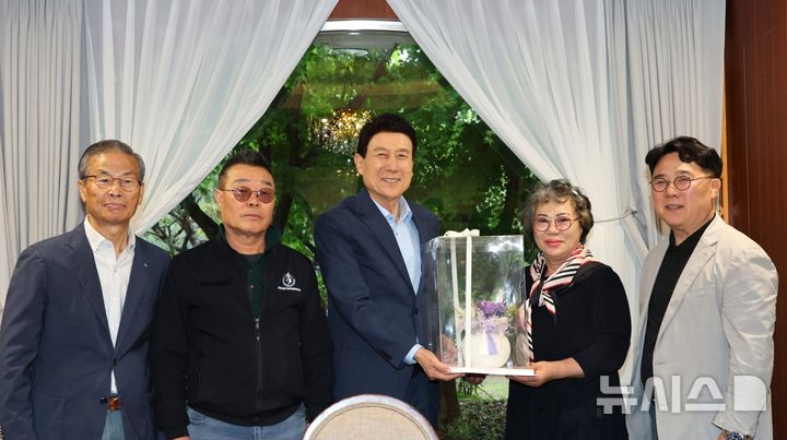 [포항=뉴시스] 이강덕 포항시장은 9일 지역 대표 전통시장인 죽도시장 상인을 만나 간담회를 열고 지역 상권의 현안과 향후 발전 방향에 논의했다. 간담회에 앞서 상인들이 이 시장에게 꽃 항아리를 전달하며 기념 촬영하는 모습. (사진=포항시 제공) 2025.05.09. photo@newsis.com