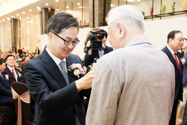 [수원=뉴시스] 9일 수원노블레스컨벤션에서 열린 제53회 어버이날 기념행사에서 김동연 지사가 임종선 사할린 동포에게 카네이션을 달아드리고 있다. (사진=경기도 제공) 2025.05.09. photo@newsis.com *재판매 및 DB 금지