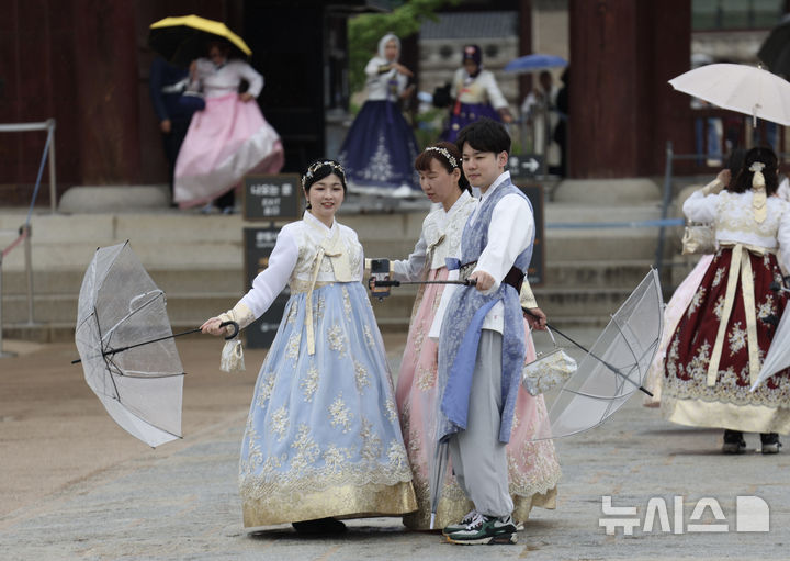 [서울=뉴시스] 김명년 기자 = 비가 내린 9일 오전 서울 종로구 경복궁에서 한복을 입은 외국인 관광객들이 기념촬영하고 있다. 2025.05.09. kmn@newsis.com