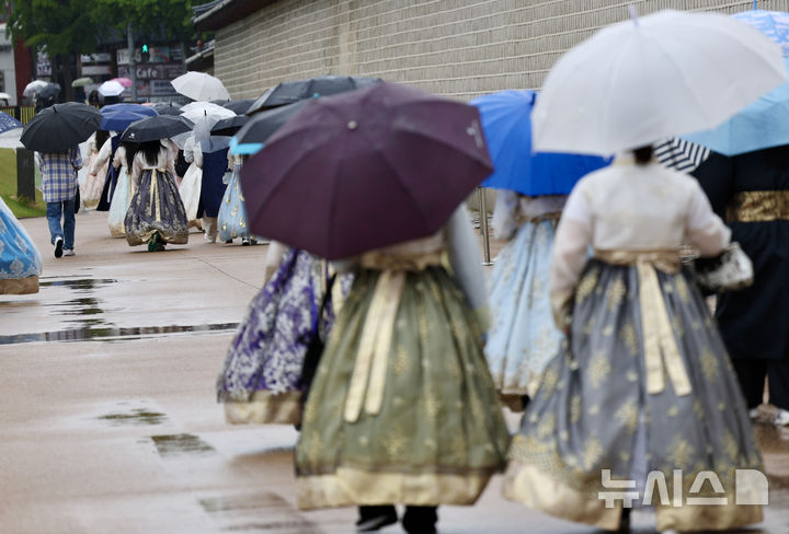 [서울=뉴시스] 김명년 기자 = 비가 내린 9일 오전 서울 종로구 경복궁에서 한복을 입은 관광객들이 우산을 쓰고 산책을 하고 있다. 2025.05.09. kmn@newsis.com