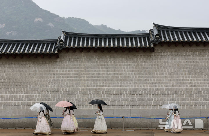[서울=뉴시스] 김명년 기자 = 비가 내린 9일 오전 서울 종로구 경복궁에서 한복을 입은 관광객들이 우산을 쓰고 산책을 하고 있다. 2025.05.09. kmn@newsis.com