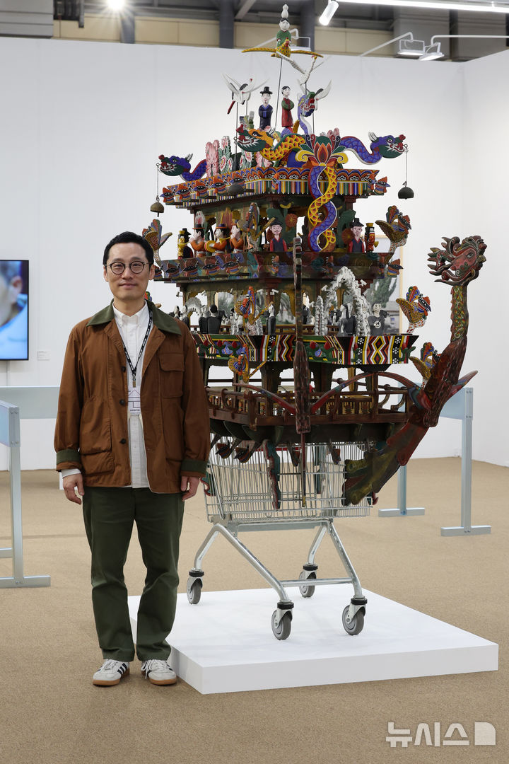 [부산=뉴시스] 박진희 기자 = 고원석 라인문화재단 디렉터가 9일 부산 해운대구 벡스코 전시장에서 열리고 있는 '아트부산 2025' 김상돈 작가의 작품 '카트'을 살펴보고 있다. 2025.05.09. pak7130@newsis.com