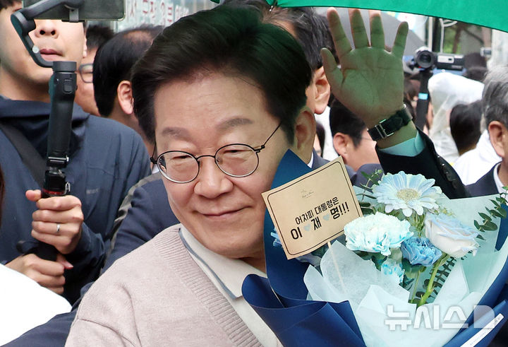 [칠곡=뉴시스] 조성우 기자 = 민심을 청취하는 '경청 투어'에 나선 이재명 더불어민주당 대선후보가 9일 경북 칠곡군 석적읍 인근에서 한 지지자로부터 꽃다발을 받아 들고 있다. 2025.05.09. xconfind@newsis.com