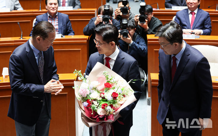 [서울=뉴시스] 권창회 기자 = 김문수 국민의힘 대선 후보가 9일 오전 서울 여의도 국회에서 열린 의원총회에서 권영세 비상대책위원장과 권성동 원내대표에게 꽃다발을 받고 자리로 이동하고 있다. 2025.05.09. kch0523@newsis.com