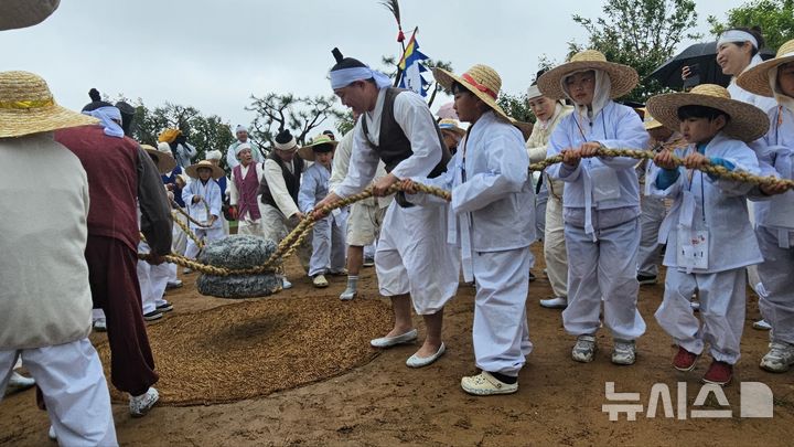 [화성=뉴시스]문영호 기자=화성시 팔탄면향토민요보존회가 10일 개최한 '제9회 화성팔탄민요 전통 모심기 재현 및 체험행사'에 참가한 아이들이 보존회 회원들과 함께 지경다지기를 하고 있다.2025.05.10.sonanom@newsis.com