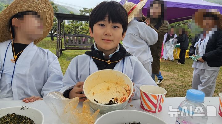 [화성=뉴시스]문영호 기자=10일 '제9회 화성팔탄민요 전통 모심기 재현 및 체험행사'에 참여한 화성 청림초 조윤우 군이 들나물주먹밥을 만들어 먹은 후 비운 그릇을 내보이고 있다.2025.05.10.sonanom@newsis.com 