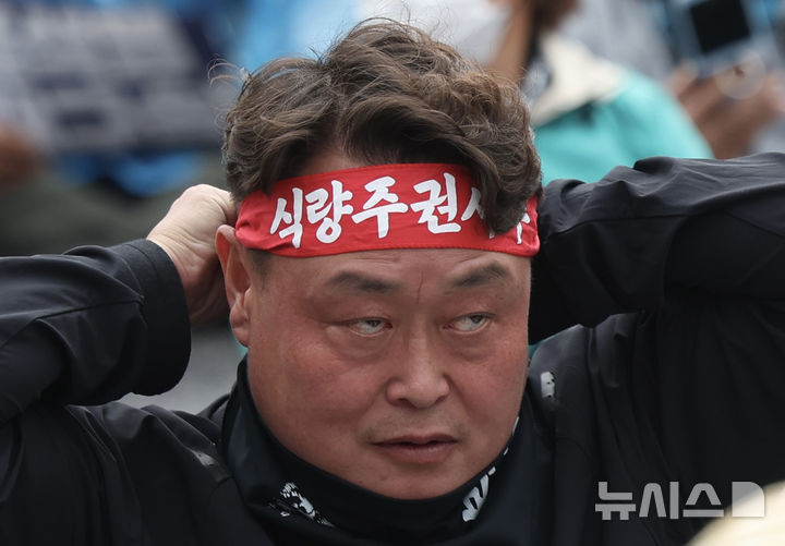 [서울=뉴시스] 김명년 기자 = 10일 오후 서울 종로구 경복궁 동십자각 인근에서 열린 '전봉준투쟁단 내란농정 청산 농업대개혁 범시민대회'에서 농민이 머리띠를 두르고 있다. 2025.05.10. kmn@newsis.com