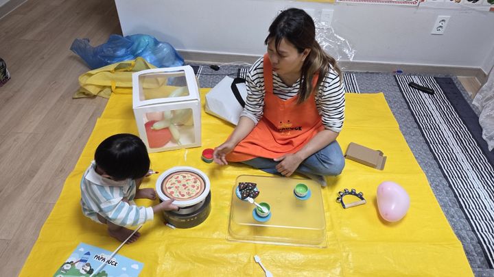 [서울=뉴시스] 전문 미술 강사와 아동이 함께 베이커리 놀이를 하고 있다. 2025.05.11. (사진=구로구 제공) *재판매 및 DB 금지