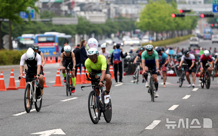 [대구=뉴시스] 이무열 기자 = 11일 대구 수성구 수성못과 신천동로에서 열린 ‘제21회 대구광역시장배 전국철인3종대회’에 출전한 참가자들이 힘차게 사이클 페달을 밟고 있다. 2025.05.11. lmy@newsis.com