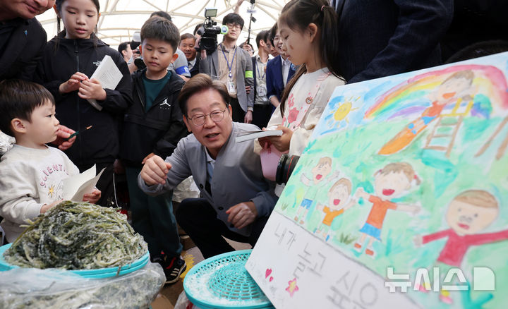 [강진=뉴시스] 조성우 기자 = 민심을 청취하는 '경청 투어'에 나선 이재명 더불어민주당 대선후보가 11일 전남 강진군 강진오감통시장에서 한 상인의 자녀들과 만나 대화하고 있다. 2025.05.11. xconfind@newsis.com
