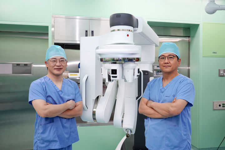 [부산=뉴시스] 해운대백병원 갑상선·내분비외과 구도훈 교수(오른쪽)와 배동식 교수가 다빈치 SP 로봇수술기 앞에서 기념촬영을 하고 있다. (사진=해운대백병원 제공) 2025.05.12. photo@newsis.com *재판매 및 DB 금지