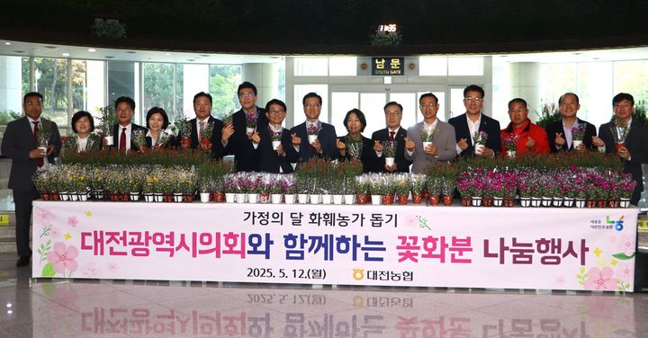 [대전=뉴시스] 조명휘 기자 = NH농협은행 대전본부가 가정의 달을 맞아 12일 지역 화훼농가를 돕고 꽃소비 문화를 확산하기 위해 시의회에서 꽃화분 나눔행사를 열고 있다. (사진= 농협대전본부 제공) 2025.05.12. photo@newsis.com *재판매 및 DB 금지