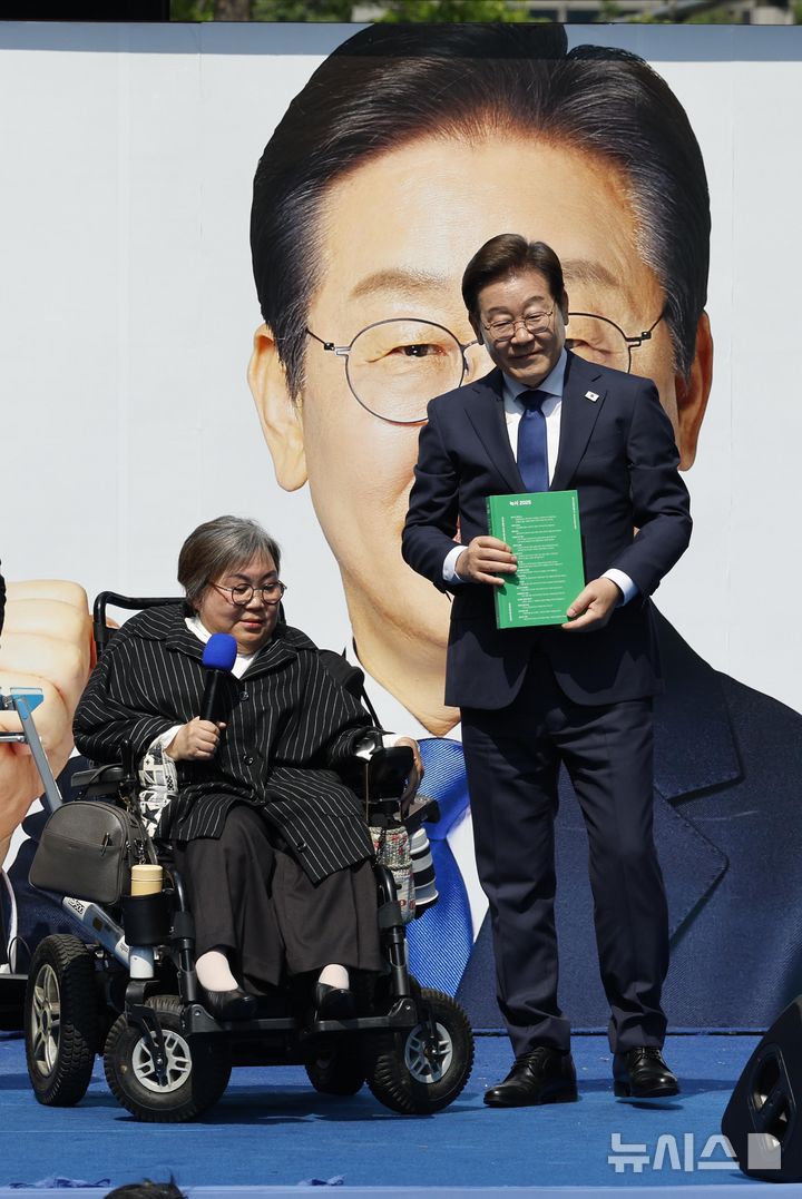 [서울=뉴시스] 조성우 기자 = 이재명 더불어민주당 대선후보가 제21대 대통령선거 공식 선거운동이 시작된 12일 오전 서울 청계광장에서 열린 중앙선거대책위원회 출정식에서 박김영희 씨에게 모두의 질문Q 녹서를 전달받고 있다. (공동취재) 2025.05.12. photo@newsis.com