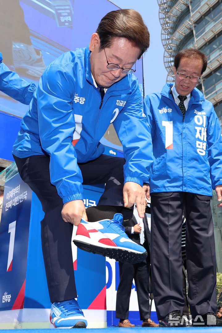 [서울=뉴시스] 조성우 기자 = 이재명 더불어민주당 대선후보가 제21대 대통령선거 공식 선거운동이 시작된 12일 오전 서울 청계광장에서 열린 중앙선거대책위원회 출정식 및 첫 유세에서 운동화를 신고 있다. (공동취재) 2025.05.12. photo@newsis.com