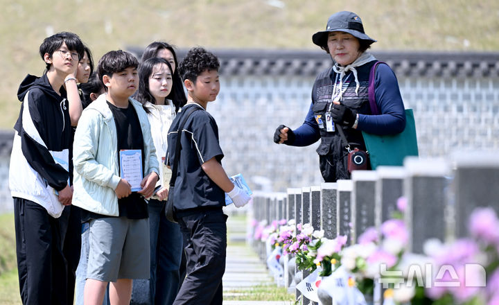 [광주=뉴시스] 김혜인 기자 = 광주 5·18민주화운동 45주년 엿새를 앞둔 12일 오전 광주 북구 국립 5·18민주묘지에서 학생들이 해설사로부터 희생자에 대한 설명을 듣고 있다. 2025.05.12. hyein0342@newsis.com