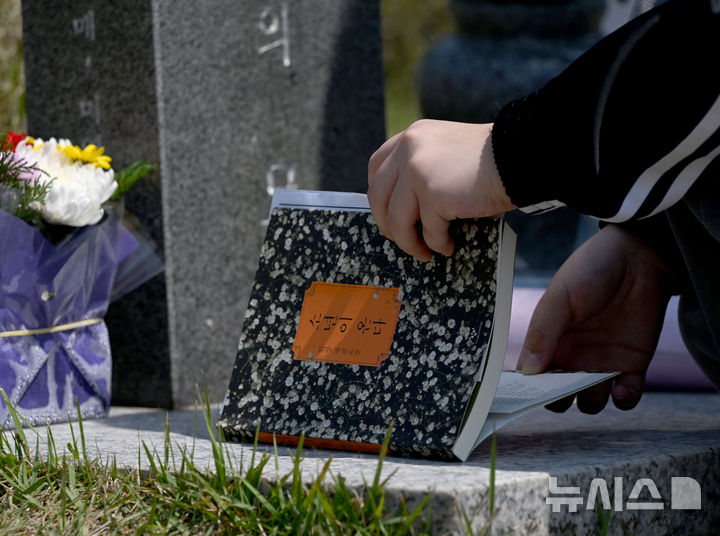 [광주=뉴시스] 김혜인 기자 = 광주 5·18민주화운동 45주년 엿새를 앞둔 12일 오전 광주 북구 국립 5·18민주묘지에서 학생들이 한강 작가의 '소년이 온다' 책 주인공 '동호' 실존 인물인 문재학 열사의 묘소를 참배하던 중 소설 '소년이 온다'를 제단에 바치고 있다. 2025.05.12. hyein0342@newsis.com