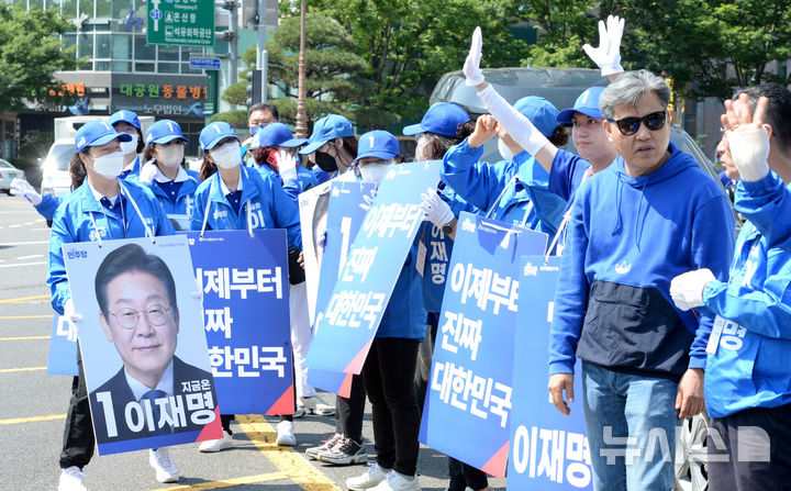 [울산=뉴시스] 배병수 기자 = 더불어민주당 울산시당이 제21대 대통령선거 공식 선거운동이 시작된 12일 오전 울산 남구 공업탑에서 열린 출정식에서 운동원들이 시민들에게 이재명 후보 지지를 호소하고 있다. 2025.05.12.bbs@newsis.com.