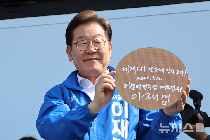 [화성=뉴시스] 조성우 기자 =이재명 더불어민주당 대선후보가 제21대 대통령선거 공식 선거운동이 시작된 12일 경기 화성시 동탄 센트럴파크 음악분수중앙광장에서 열린 집중유세에서 '세계1위 반도체 강국도약'이라고 쓴 반도체 웨이퍼를 들어보이고 있다. (공동취재) 2025.05.12. photo@newsis.com