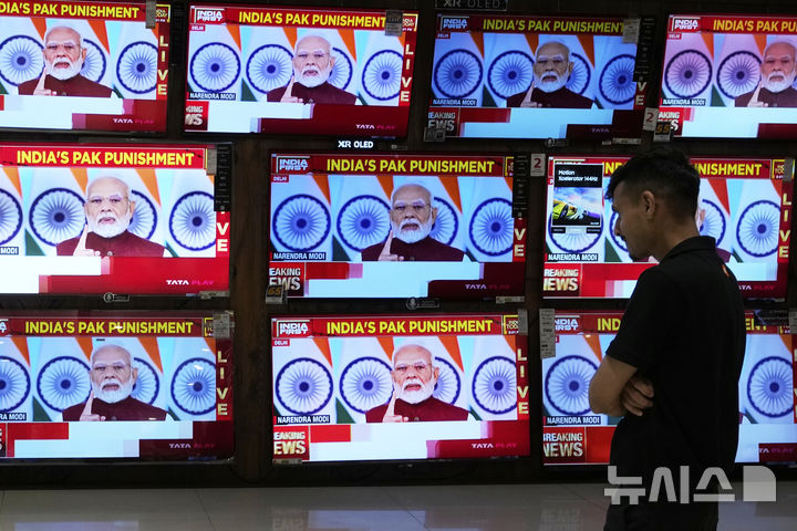 [뭄바이=AP/뉴시스]12일(현지 시간) 인도의 뭄마이의 한 쇼핑몰에서 TV를 통해 나렌드라 모디 총리의 대국민 연설이 생중계되고 있다. 20255.05.13.