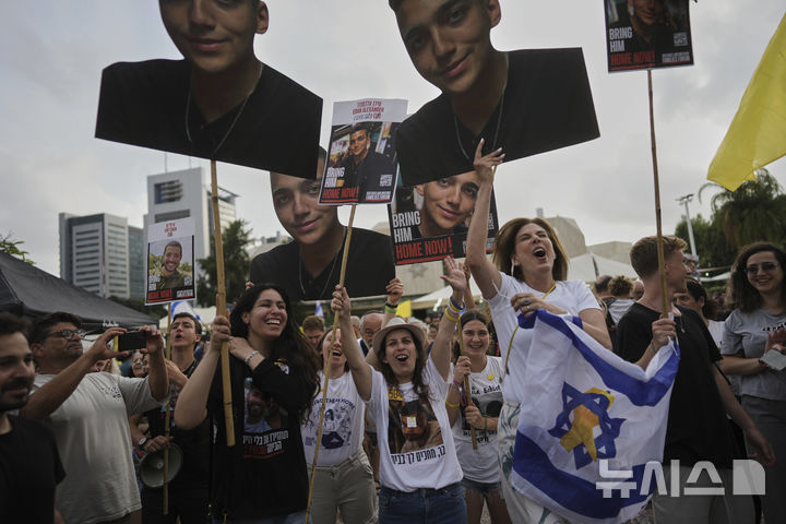 [텔아비브=AP/뉴시스] 12일(현지 시간) 이스라엘 텔아비브 인질 광장에서 모인 사람들이 미국·이스라엘 이중국적 병사 에단 알렉산더가 팔레스타인 무장 정파 하마스로부터 석방되는 것을 생방송으로 지켜보며 환호하고 있다. 알렉산더는 미국 뉴저지 출신으로, 아직 가자지구에 억류된 마지막 미국인 생존자로 알려졌다. 2025.05.13.