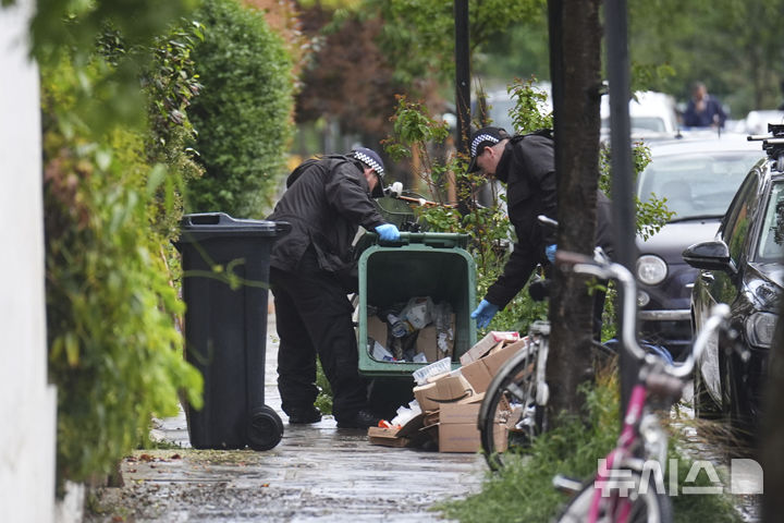 [런던=AP/뉴시스] 지난 12일(현지 시간) 영국 런던 북부 켄티시타운에 있는 키어 스타머 총리 사저에서 화재가 발생한 후 경찰관들이 사저 인근 쓰레기통을 수색하고 있다. 2025.05.13.