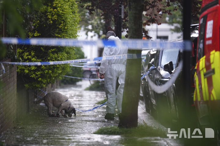 [런던=AP/뉴시스] 5월12일 영국 런던 북부 켄티시타운에 있는 키어 스타머 총리 사저에서 화재가 발생한 후 한 경찰관이 탐지견과 함께 주변을 조사하고 있다. 현지 경찰은 이날 새벽 1시경&nbsp;&nbsp; 출동한 소방대가 30분 내로 화재를 진압했으며 인명 피해는 없다고 밝혔다. 2025.05.16.