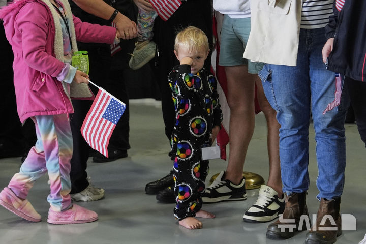 [덜레스=AP/뉴시스] 미국 국기를 든 남아프리카공화국계 아프리카너들이 12일(현지 시간) 미 버지니아주 덜레스에 있는 덜레스 국제공항에 도착하고 있다. 이날 아프리카너(16세기 이후 네덜란드 등 유럽에서 남아공으로 이주해 정착한 백인) 59명이 난민 자격으로 미국에 입국했다. 취임 뒤 사실상 난민 수용을 중단한 도널드 트럼프 행정부가 남아공 백인의 난민 지위를 인정해 미국 내 정착을 허용해 논란이 일고 있다. 2025.05.13.